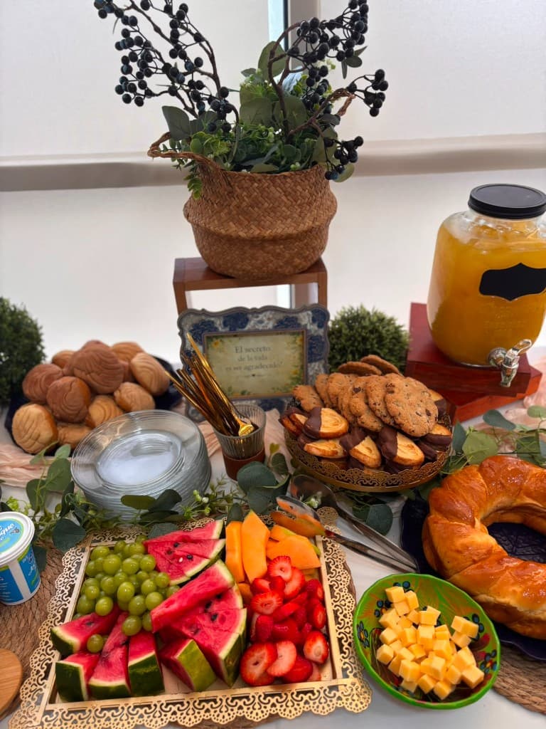 Mesa de coffee break corporativo con frutas, jugos y panadería